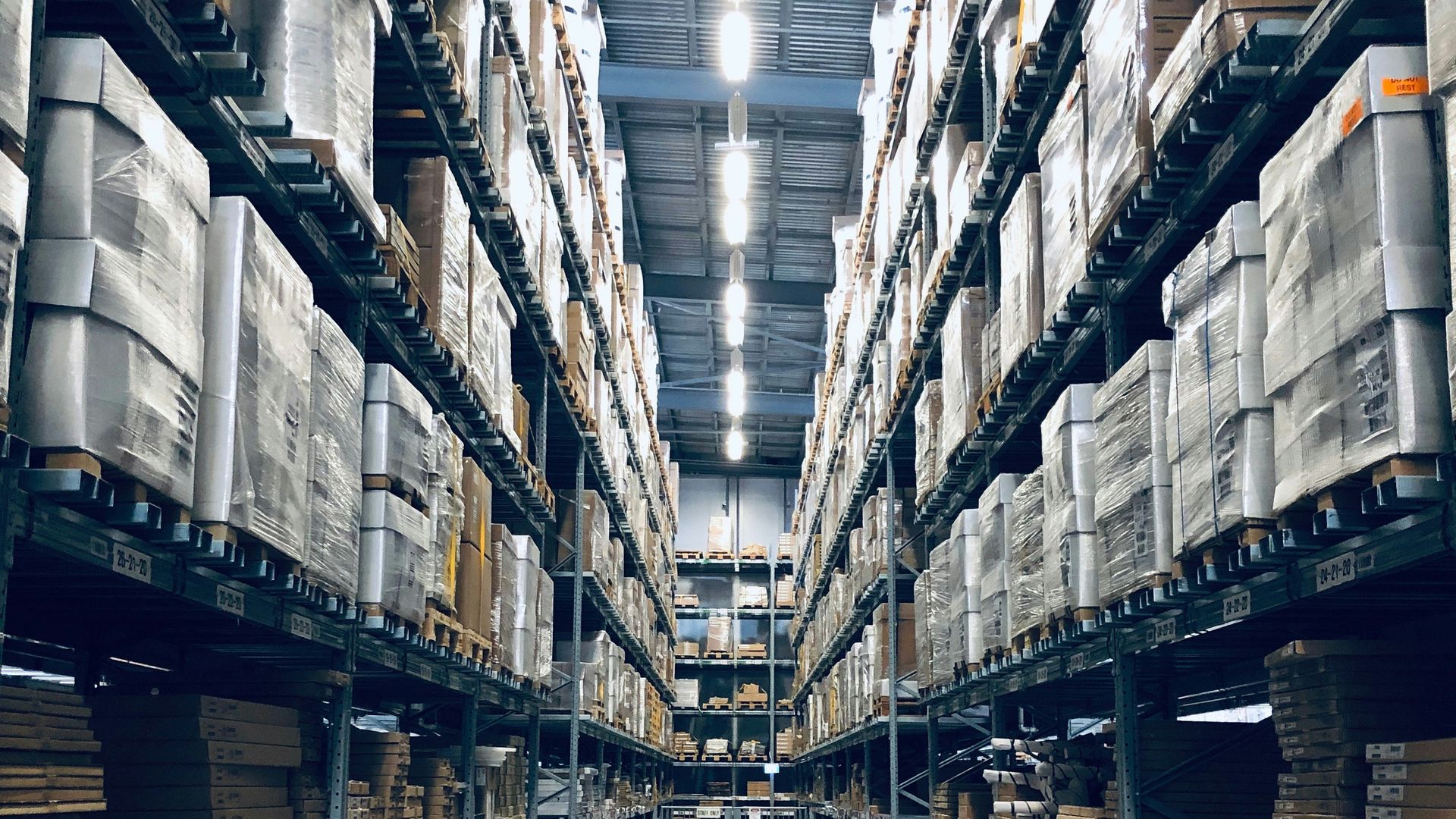 ممر مستودع تصطفّ على جانبيه رفوف البضائع